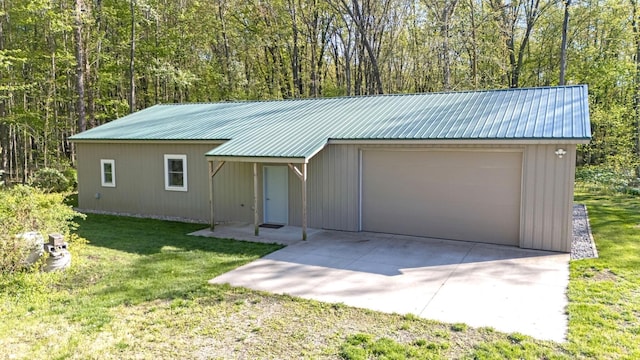 4624 Parman Rd, Stockbridge, MI 49285 - view of front of home featuring metal roof, a garage, a front yard, and a wooded view
