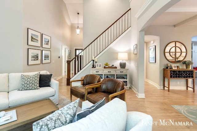 2078 Chippewa Dr Unit 25, Holland, MI 49424 - living room featuring arched walkways, light wood finished floors, baseboards, stairs, and a high ceiling