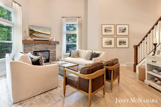 2078 Chippewa Dr Unit 25, Holland, MI 49424 - living area with a towering ceiling, light wood finished floors, a fireplace, plenty of natural light, and stairs