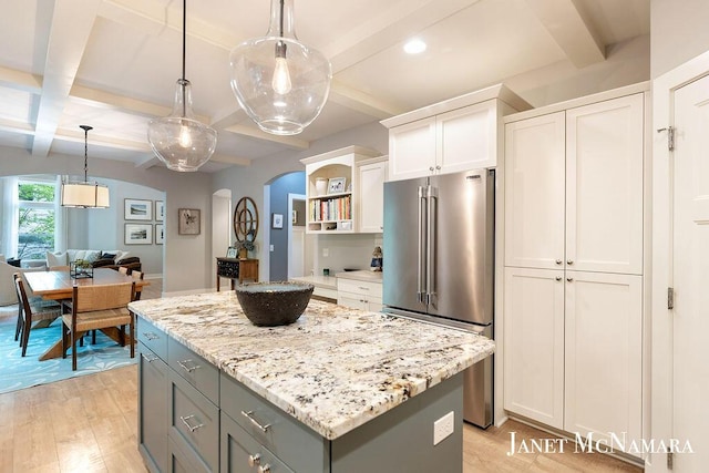 2078 Chippewa Dr Unit 25, Holland, MI 49424 - kitchen featuring high quality fridge, a kitchen island, beam ceiling, open shelves, and light wood-type flooring