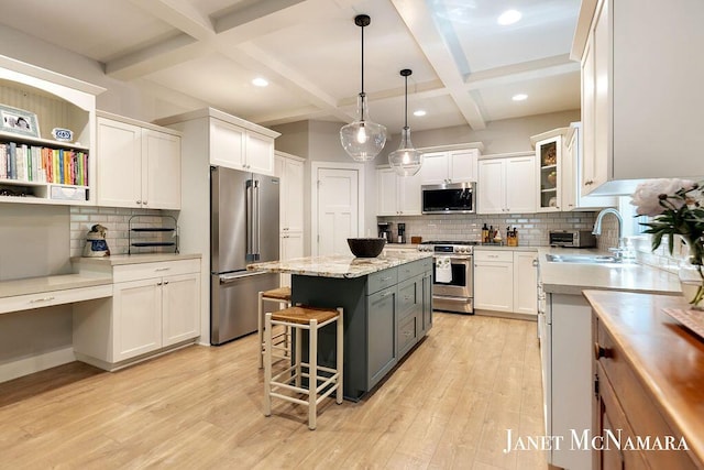 2078 Chippewa Dr Unit 25, Holland, MI 49424 - kitchen with appliances with stainless steel finishes, a kitchen island, decorative backsplash, white cabinets, and coffered ceiling