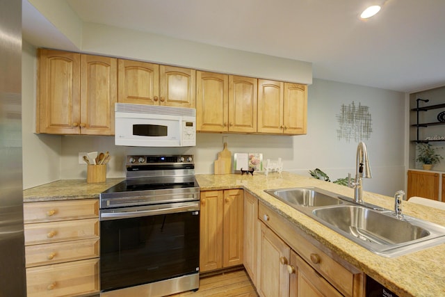 843 Greenhills Dr, Ann Arbor, MI 48105 - kitchen with stainless steel appliances, a sink, light brown cabinetry, light countertops, and light wood-style flooring