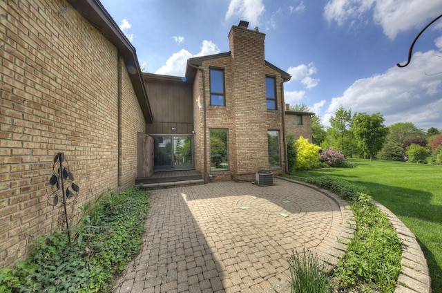 843 Greenhills Dr, Ann Arbor, MI 48105 - rear view of house featuring a chimney, a yard, brick siding, and a patio area