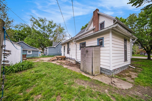 237 E Main St, Milan, MI 48160 - view of property exterior featuring a chimney and a lawn
