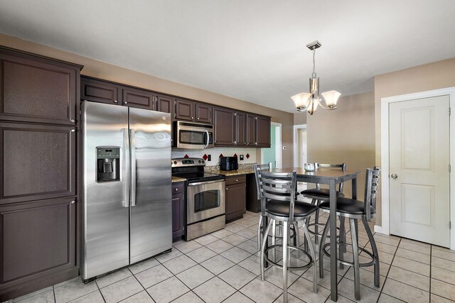 17270 Taft Rd, Spring Lake, MI 49456 - kitchen featuring stainless steel appliances, a chandelier, light tile patterned floors, dark brown cabinets, and backsplash