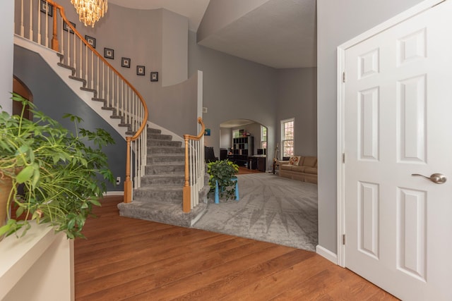 1218 Waterways Dr, Ann Arbor, MI 48108 - entryway with arched walkways, stairs, wood finished floors, baseboards, and a high ceiling