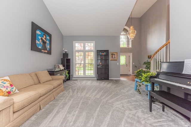 1218 Waterways Dr, Ann Arbor, MI 48108 - carpeted living area featuring a chandelier, high vaulted ceiling, baseboards, and stairway