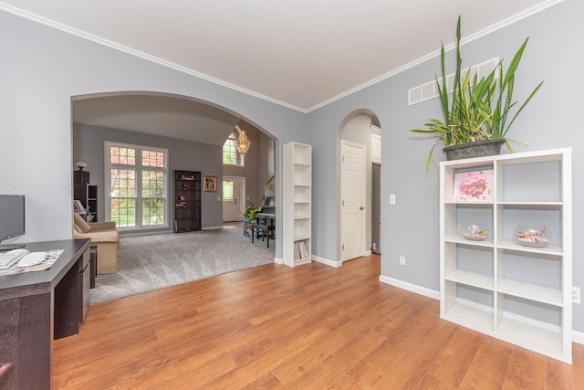 1218 Waterways Dr, Ann Arbor, MI 48108 - unfurnished living room featuring arched walkways, light wood-style floors, ornamental molding, baseboards, and stairway