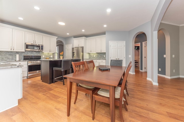 1218 Waterways Dr, Ann Arbor, MI 48108 - dining area with arched walkways, light wood-style flooring, baseboards, recessed lighting, and ornamental molding
