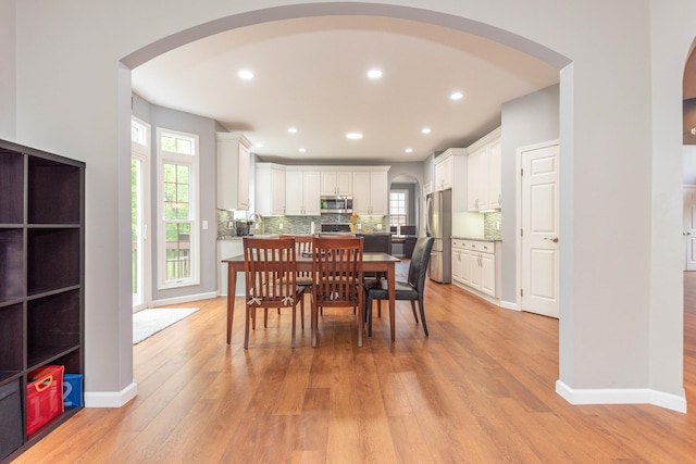 1218 Waterways Dr, Ann Arbor, MI 48108 - dining room with arched walkways, light wood-style flooring, recessed lighting, and baseboards