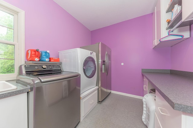 1218 Waterways Dr, Ann Arbor, MI 48108 - laundry area featuring cabinet space, healthy amount of natural light, washing machine and dryer, and baseboards