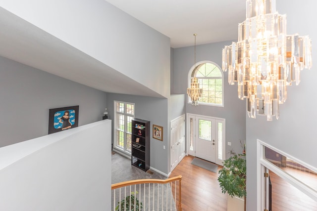 1218 Waterways Dr, Ann Arbor, MI 48108 - foyer featuring a chandelier, wood finished floors, healthy amount of natural light, a towering ceiling, and baseboards