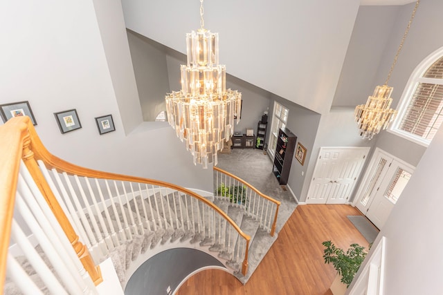 1218 Waterways Dr, Ann Arbor, MI 48108 - staircase with a chandelier, a high ceiling, wood finished floors, and a lit fireplace