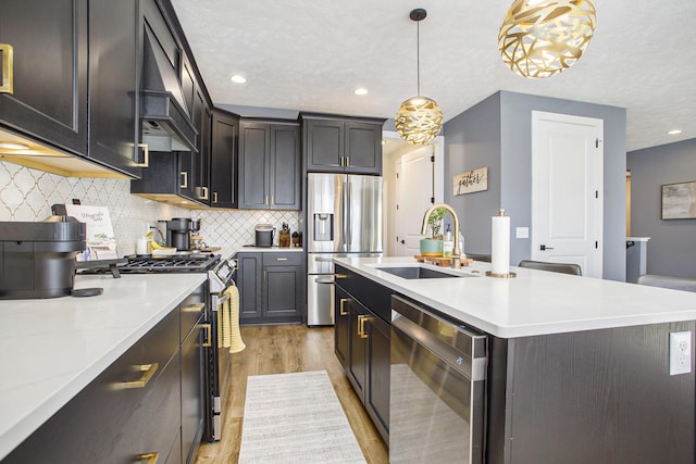 821 Janelle Ct, Portage, MI 49024 - kitchen with stainless steel appliances, a sink, light wood-style floors, light countertops, and pendant lighting
