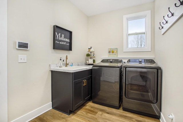 821 Janelle Ct, Portage, MI 49024 - washroom with washing machine and clothes dryer, baseboards, light wood-style floors, and cabinet space