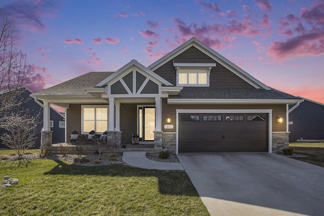 821 Janelle Ct, Portage, MI 49024 - craftsman house with covered porch, a lawn, driveway, stone siding, and roof with shingles