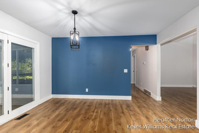 empty room featuring baseboards and wood finished floors