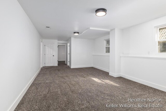 carpeted spare room featuring baseboards