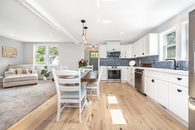 1435 Harpst St, Ann Arbor, MI 48104 - kitchen featuring stainless steel appliances, a sink, extractor fan, decorative backsplash, and light countertops