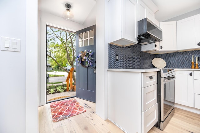 1435 Harpst St, Ann Arbor, MI 48104 - kitchen featuring extractor fan, light wood-type flooring, backsplash, stainless steel electric stove, and white cabinets