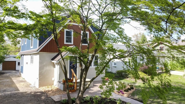 1435 Harpst St, Ann Arbor, MI 48104 - view of front of property with an outbuilding, a garage, stucco siding, and driveway