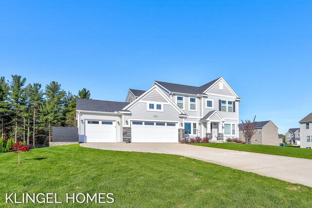 9235 Bigleaf Dr, West Olive, MI 49460 - view of front facade with concrete driveway, a front lawn, stone siding, and a garage
