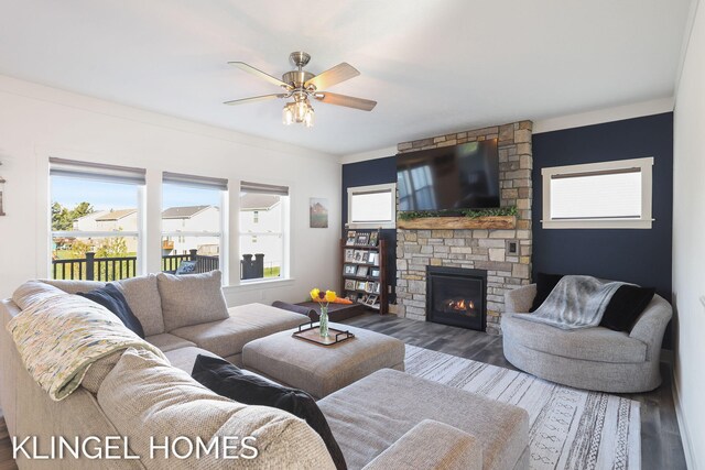 9235 Bigleaf Dr, West Olive, MI 49460 - living area featuring wood finished floors, a ceiling fan, and a stone fireplace