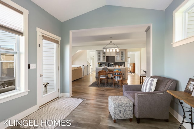 9235 Bigleaf Dr, West Olive, MI 49460 - living room featuring lofted ceiling, dark wood-type flooring, a chandelier, and baseboards