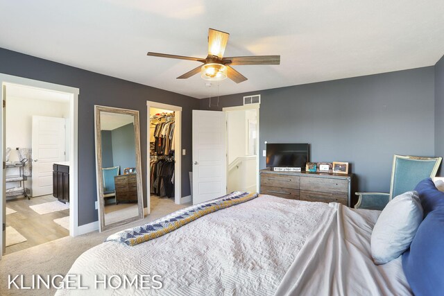 9235 Bigleaf Dr, West Olive, MI 49460 - bedroom featuring light colored carpet, a walk in closet, ensuite bath, a closet, and a ceiling fan