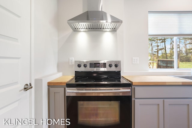 9235 Bigleaf Dr, West Olive, MI 49460 - kitchen with wooden counters, wall chimney exhaust hood, and stainless steel electric range