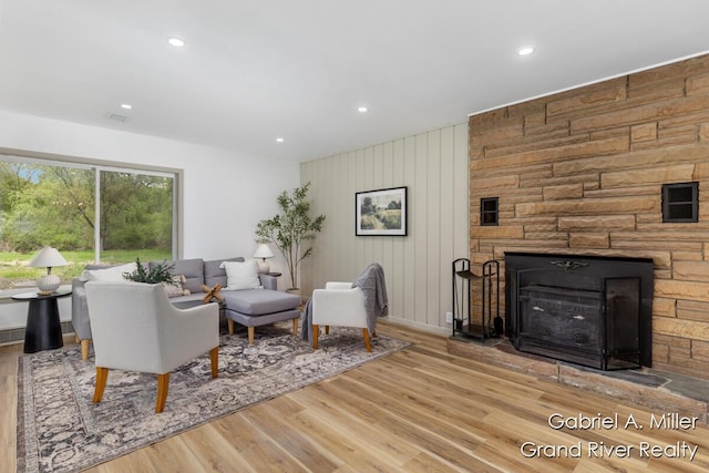 living room with wood finished floors, recessed lighting, a fireplace, and baseboards