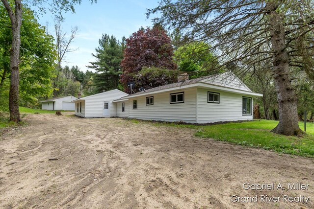 rear view of house featuring a garage and a lawn
