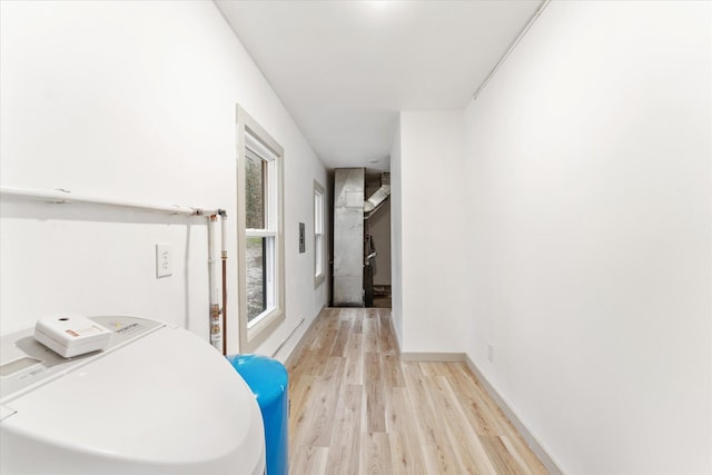 washroom featuring washer / dryer, light wood-type flooring, and baseboards
