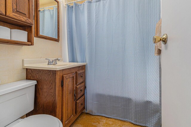 bathroom with toilet, vanity, and a shower with curtain