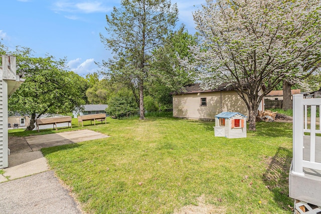 view of grassy yard with an outdoor structure and a storage unit