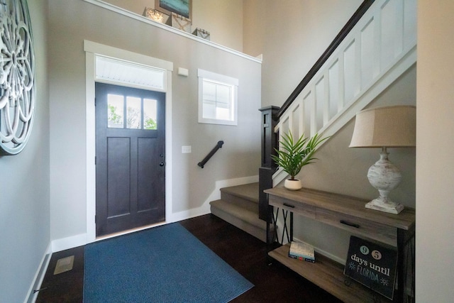 foyer with stairs and baseboards
