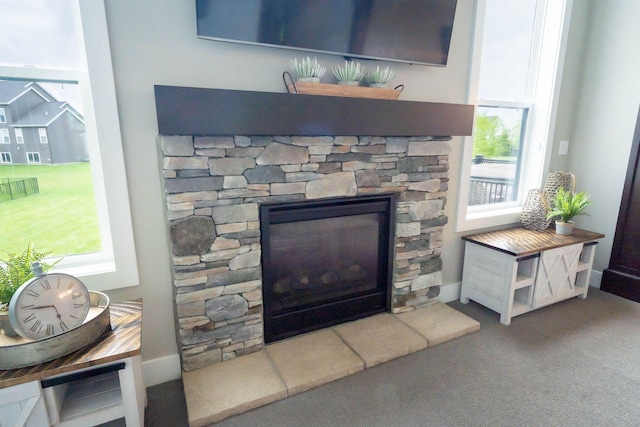 detailed view of a stone fireplace and carpet floors