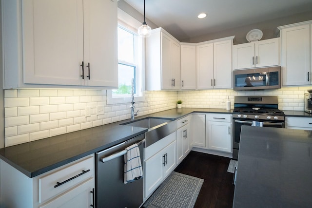 kitchen with appliances with stainless steel finishes, dark countertops, white cabinetry, decorative backsplash, and recessed lighting