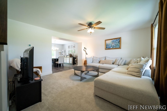 living area featuring a chandelier, carpet, a ceiling fan, and baseboards