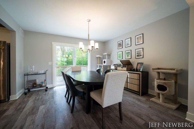 dining area with a chandelier, dark wood-type flooring, and baseboards
