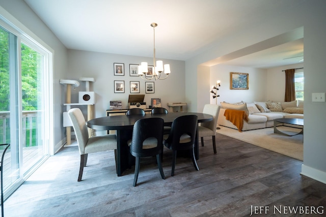 dining area featuring a chandelier, dark wood-type flooring, and plenty of natural light