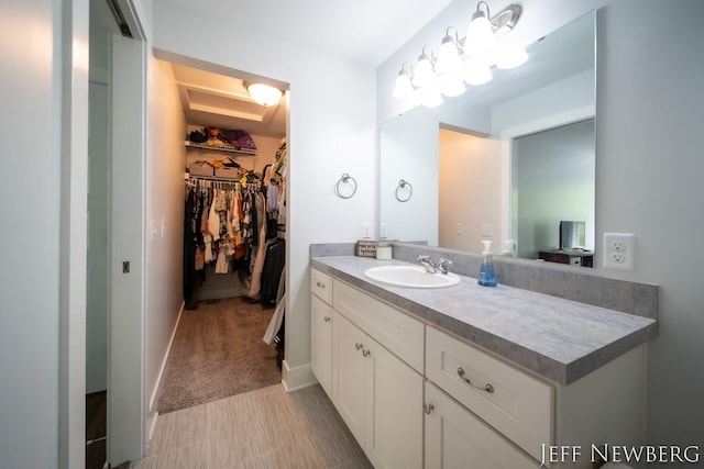 bathroom with vanity and a walk in closet