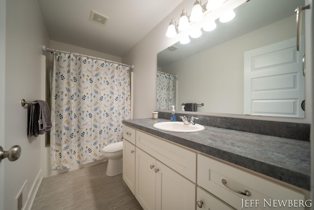bathroom with toilet, vanity, and curtained shower