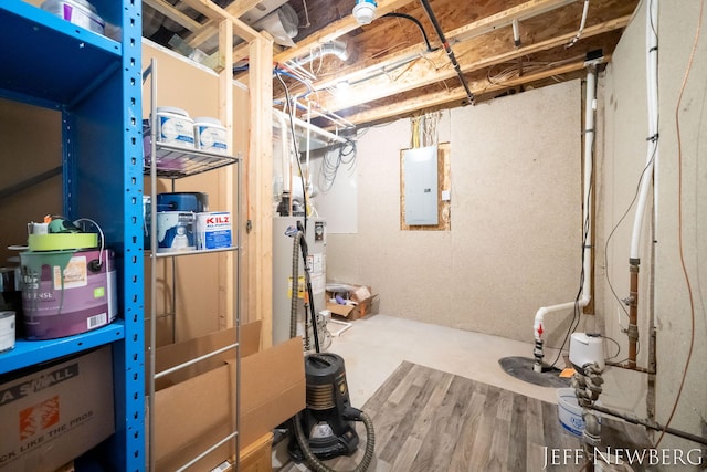 unfinished below grade area with electric panel and gas water heater