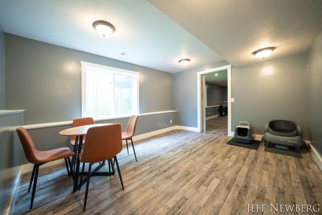 dining area with baseboards, wood finished floors, and a textured ceiling