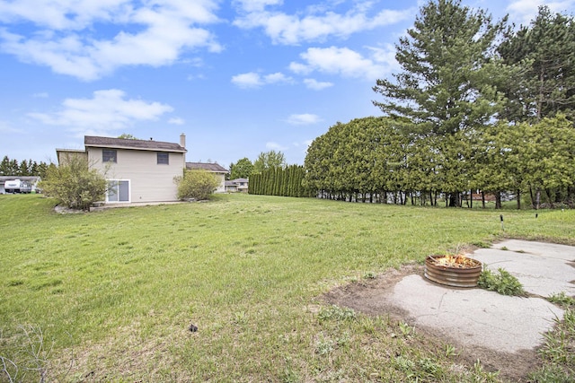6001 Dover Ln, Traverse City, MI 49684 - view of grassy yard with a fire pit