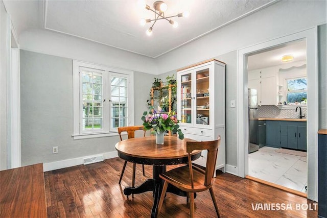 dining room featuring healthy amount of natural light, a chandelier, and dark wood-type flooring