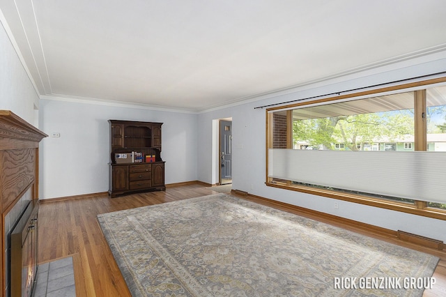 28 W 34th St, Holland, MI 49423 - unfurnished living room featuring crown molding, wood finished floors, and baseboards