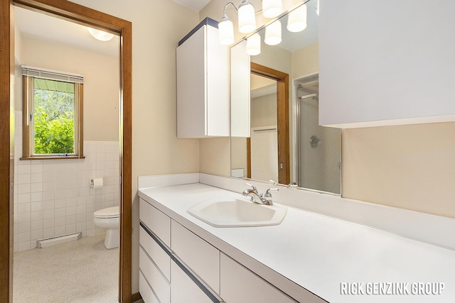 28 W 34th St, Holland, MI 49423 - bathroom with vanity, toilet, tile walls, wainscoting, and a shower with door