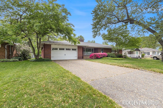 28 W 34th St, Holland, MI 49423 - ranch-style house featuring an attached garage, asphalt driveway, brick siding, a front lawn, and a chimney